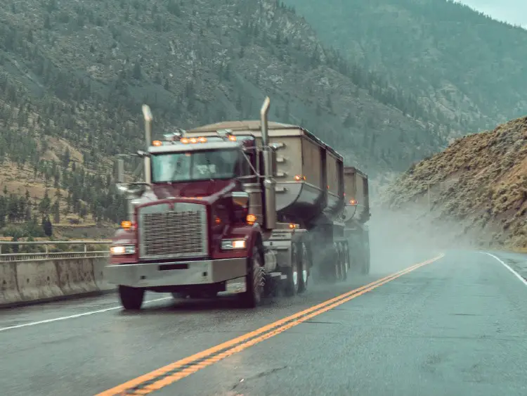tractor trailer truck driving on wet highway